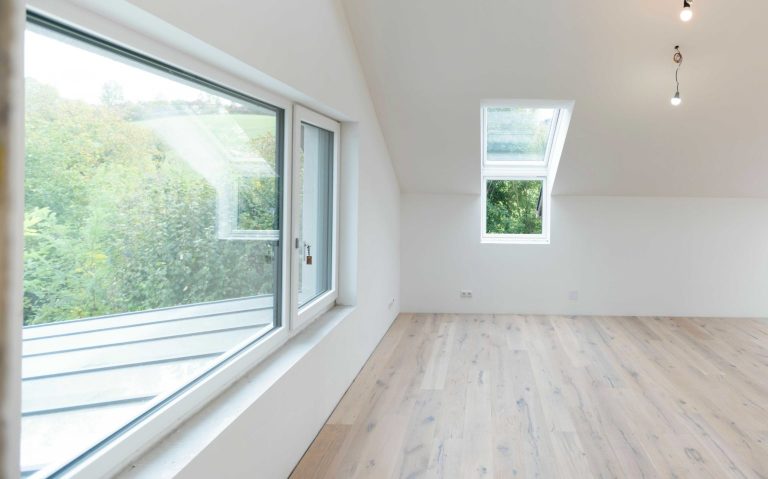 Lyst rom med stort vindu og lyst gulv. Ingen moebler